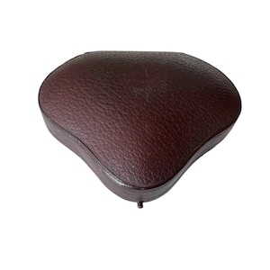 May include: A white ceramic mug with a black handle and the text "But First, Coffee" in a bold, black font. The mug is filled with a dark liquid, likely coffee, and sits on a light-colored surface.