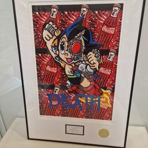 May include: A framed print of a cartoon character with a robotic head, surrounded by Coca-Cola bottles. The character is wearing a blue and red suit and has a blue cape. The print is signed "DEATH NYC".