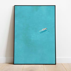 May include: A framed photograph of a person floating on their back in a turquoise body of water. The person is wearing a swimsuit and is facing the sky.