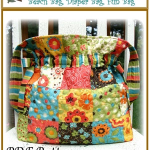 Könnte beinhalten: Eine bunte Patchwork-Kordeltasche mit einem gestreiften Riemen. Die Tasche ist aus gestepptem Stoff mit einem Blumenmuster. Der Text "Jumbo Drawstring Bag" befindet sich oben im Bild. Der Text "Beach Bag, Diaper Bag, Fun Bag" befindet sich unter dem Titel. Der Text "PDF Pattern" befindet sich unten im Bild. Der Text "Carlene Westberg Designs #cjw-011" befindet sich unten im Bild.