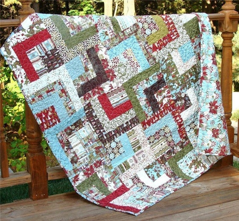May include: A patchwork quilt with a geometric pattern in shades of blue, green, red, and white. The quilt is made of various fabrics with different patterns and textures.