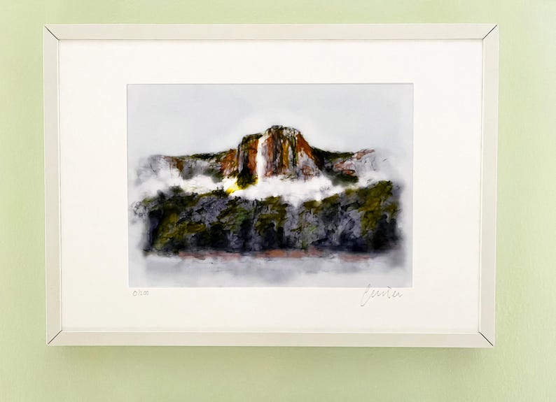 May include: A framed watercolour painting of a mountain with a waterfall cascading down the side. The mountain is surrounded by trees and fog. The painting is signed "Jenita" in the bottom right corner.