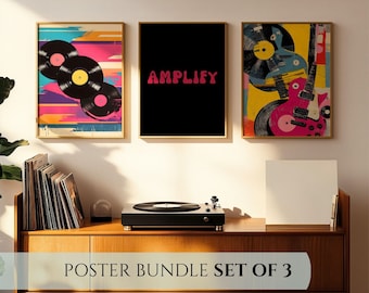 May include: A set of three framed art prints. One print features vinyl records, another has the word "AMPLIFY" in pink, and the third showcases a guitar and record design. The prints are displayed above a wooden cabinet.