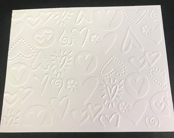 May include: White embossed paper with a repeating pattern of hearts, swirls, and other abstract shapes.