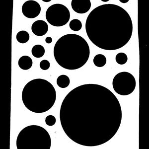 May include: A white stencil sheet featuring a pattern of black circles of varying sizes. The circles are densely arranged across the sheet, creating a bold, graphic design. The contrast between the black shapes and the white background is striking.