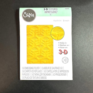 May include: A yellow 3-D textured embossing folder with a floral design. The folder is labeled "3-D Textured Impressions" and "Kathrin Breen".