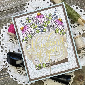 May include: A handmade card with a white doily border and a gold glitter design that says "Thinking of you". The card features a bouquet of pink flowers in a brown pot.