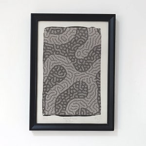 Pode incluir: Uma obra de arte emoldurada com uma moldura preta. A obra apresenta um padrão abstrato em preto e cinza com o texto "Recursion Black" na parte inferior. A impressão é numerada 1/12.