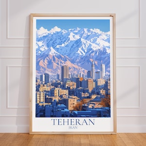 以下が含まれることがあります： イランのテヘランの街並みを、雪をかぶった山々と青い空を背景に描いたフレーム入りプリント。プリントには、都市名と国名がネイビーブルーのフォントで表示されています。