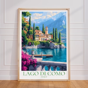 Peut inclure: Une affiche encadrée du lac de Côme, en Italie, représentant un village pittoresque au bord du lac avec une tour, une végétation luxuriante et des montagnes en arrière-plan. L'affiche est dans un cadre en bois et porte le texte "LAGO DI COMO ITALY".