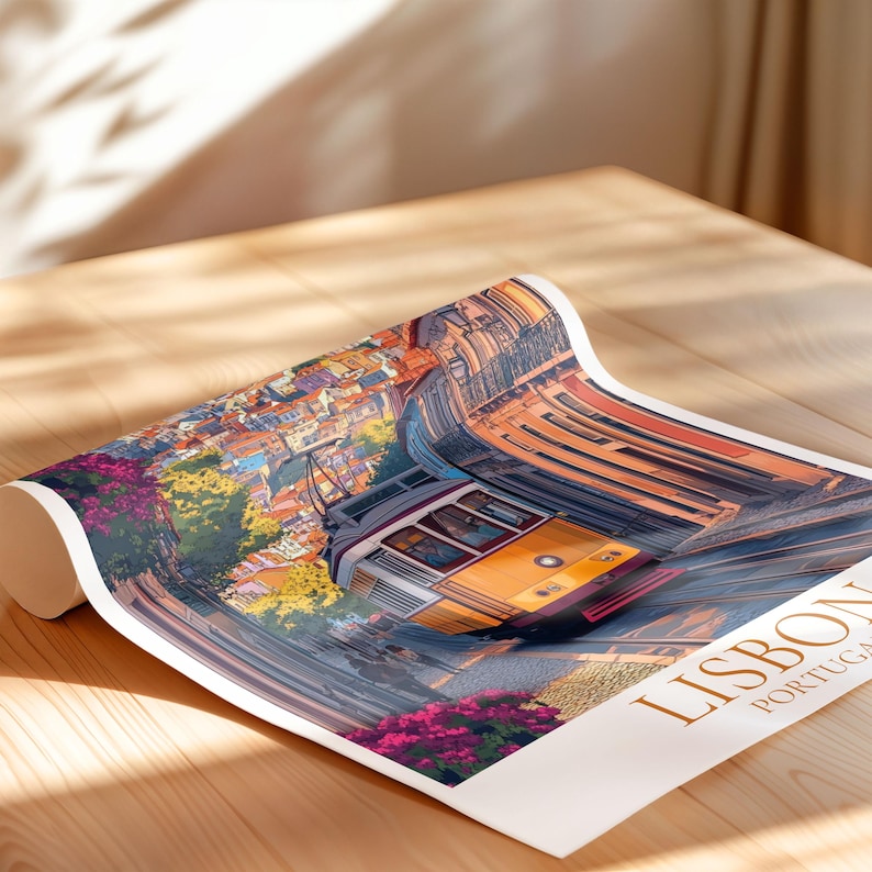 May include: Rolled poster with a colourful illustration of a yellow tram in a European city. The artwork shows buildings, flowers, and the text "LISBON PORTUGAL". The poster is on a wooden surface.