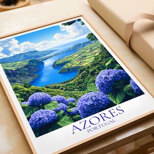 May include: A framed print featuring a vibrant landscape of the Azores, Portugal. The artwork showcases a blue lake surrounded by green hills and lush vegetation, with large clusters of blue hydrangeas in the foreground. The word "AZORES" is printed in a dark blue font.