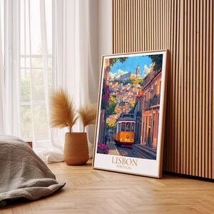 May include: A framed art print depicting a street scene in Lisbon, Portugal. A yellow tram travels along a cobbled street, with colourful buildings and a church in the background. The print is in a gold frame, with the text "LISBON PORTUGAL" at the bottom.