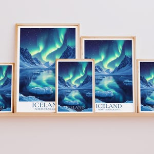 May include: A collection of framed art prints depicting the Northern Lights over Iceland. The prints showcase a vivid display of green and blue lights reflected in the water, with snow-covered mountains. The word "ICELAND" is printed at the bottom.