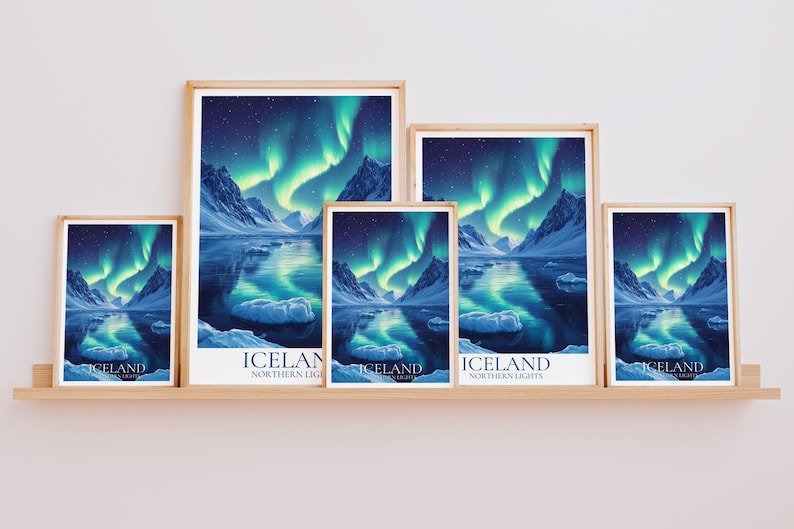 May include: A collection of framed art prints depicting the Northern Lights over Iceland. The prints showcase a vivid display of green and blue lights reflected in the water, with snow-covered mountains. The word "ICELAND" is printed at the bottom.