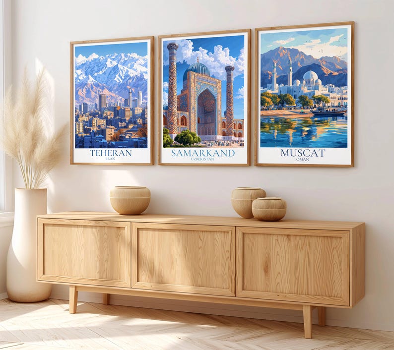 Peut inclure: Trois impressions d'art encadr&eacute;es repr&eacute;sentant des paysages urbains. Les impressions repr&eacute;sentent T&eacute;h&eacute;ran, Samarkand et Mascate, chacune avec une architecture et un arri&egrave;re-plan naturel uniques. Les impressions sont dans des cadres en bois et sont expos&eacute;es au-dessus d'un meuble en bois.