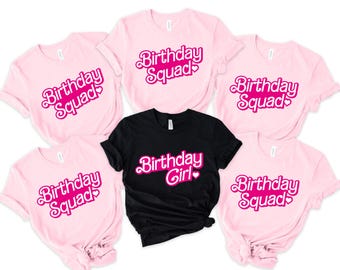 May include: Five pink t-shirts with the text "Birthday Squad" in pink lettering and a pink heart. One black t-shirt with the text "Birthday Girl" in pink lettering and a pink heart.