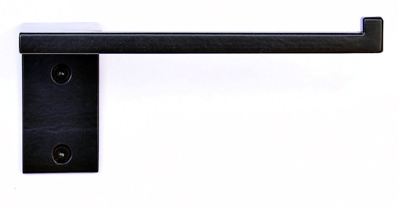May include: Black metal toilet paper holder with a square design. The holder is mounted to the wall with two screws.