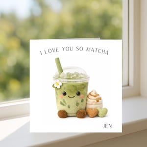 May include: A white square card with the words "I LOVE YOU SO MATCHA". The card shows a plush matcha drink with a smiling face, a flower, and a straw. Next to it are a plush dessert and heart shapes. The name "JEN" is at the bottom.