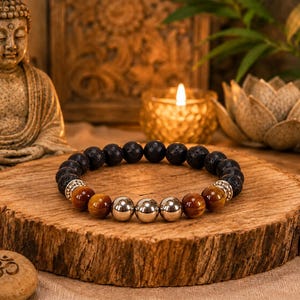 May include: A beaded bracelet featuring dark porous lava stone beads, smooth golden-brown tiger eye beads, and three central polished silver-tone metallic beads, accented with small silver-tone spacers between the different stone types.