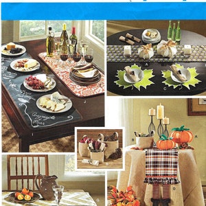 Op de afbeelding: Een Simplicity patroonvel met diverse woondecoratie-artikelen. De afbeelding toont tafereeltjes met kaas- en fruitplanken, decoratieve pompoenen en een tafelloper met heksenbenen. Het vel bevat ook tekst en een barcode.