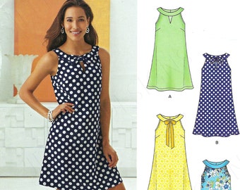 May include: A woman in a navy and white polka dot dress with a keyhole neckline. The image also shows illustrations of other dresses, including a green dress, a yellow dress, and a blue floral dress. The pattern is New Look 6263.
