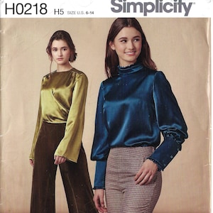 Puede incluir: Un patrón de costura para cuatro blusas diferentes. El patrón incluye una blusa azul, rosa, blanca con lunares negros y verde. El patrón es para las tallas españolas 38-46. El número del patrón es H0218.