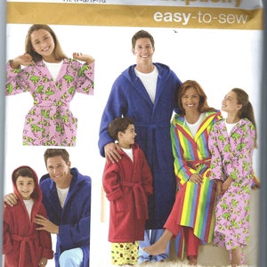 May include: Simplicity sewing pattern 3575 for hooded robes in sizes XS-L and XS-XL. The pattern features four variations: a solid blue robe, a solid red robe, a multi-colored striped robe, and a pink robe with a green and yellow fruit print.