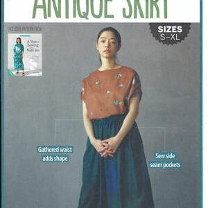 Op de afbeelding: Een vrouw draagt een bruine top met bloemenborduurwerk en een lange, teal rok. De rok heeft een geplooide taille en zijnaadzakken. De tekst "ANTIQUE SKIRT" en "SIZES S-XL" is zichtbaar.