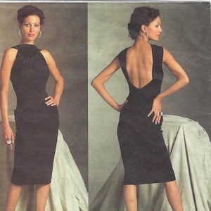 May include: A black knee-length dress featuring a high neckline and a deep open back design. The garment is shown from both the front and back views, displaying a fitted silhouette, sleeveless cut, and a solid black fabric finish. Guy Laroche Vogue Paris Original.