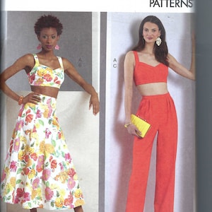 Może przedstawiać: Wzór szycia na dwuczęściowy strój, składający się z krótkiego topu i spódnicy lub spodni. Wzór jest dostępny w rozmiarach 14-22. Modelka po lewej stronie nosi spódnicę w kwiatowy wzór, a modelka po prawej stronie nosi czerwone spodnie.