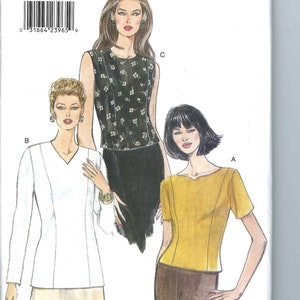 May include: A Very Easy Very Vogue sewing pattern envelope 9515 for sizes 18-20-22. The illustration displays three tops: a white long-sleeve V-neck top, a black sleeveless top with a white floral pattern, and a yellow short-sleeve top with a V-neckline.