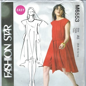 Könnte beinhalten: Ein rotes, ärmelloses Kleid mit einem Bindegürtel und einem schlichten Design. Das Kleid wird an einem Model gezeigt, im Hintergrund ist eine Skizze eines ähnlichen Kleides zu sehen. Die Schnittmuster-Nummer ist M6553 und die Größe ist A5 (6-8-10-12-14).