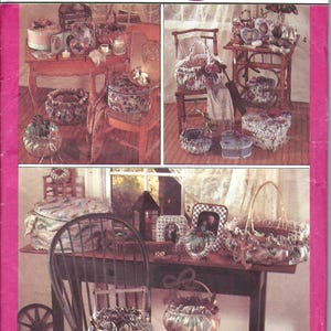 May include: Simplicity Crafts pattern featuring various fabric-covered baskets and decorative items. The image showcases several finished craft projects, including round and oval baskets, and decorative boxes. The color scheme includes floral patterns and pastel tones.