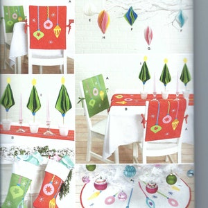 May include: Simplicity sewing pattern featuring Christmas-themed decorations. The pattern includes designs for chair covers, table runners, tree ornaments, tree skirts, and stockings. The designs feature colorful ornaments and festive details.