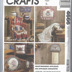 May include: McCall's Crafts pattern envelope featuring various appliqued home decor items. Designs include a rocking chair cover, pillows, and a towel holder, all with a country theme. The text reads "Heart & Sole" and "Heartwarming Appliques".