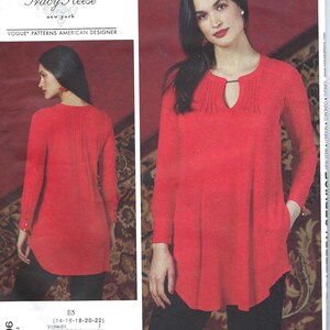 May include: A red long-sleeved tunic top with a keyhole neckline and a gathered detail at the neckline. The top has a curved hemline and a pocket on the left side. The pattern number is V1596 and the size is E5 (14-16-18-20-22).
