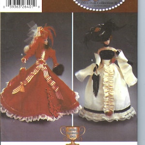 May include: Simplicity pattern 5702 for a Diva Doll Collection II, featuring two 11 1/2 inch fashion dolls. One doll wears a red and white striped dress with a white lace trim. The other doll wears a white dress with black trim and a black hat with feathers.