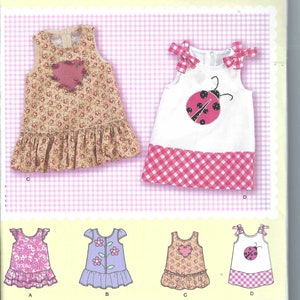 May include: Simplicity sewing pattern number 2235 for making a girl's dress. The pattern includes four different styles: a dress with a heart applique, a dress with a ladybug applique, a dress with a floral applique, and a dress with a ladybug applique and a gingham skirt. The pattern is for sizes XXS, XS, S, M, and L.
