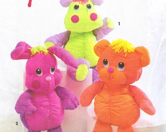 Puede incluir: Un patrón de costura Simplicity Crafts para hacer tres peluches: un monstruo verde, un conejito rosa y un oso naranja. El número del patrón es 7808.