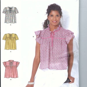 May include: A sewing pattern for a women's blouse with a ruffled neckline and short sleeves. The pattern includes three different styles: a floral print, a yellow print, and a pink print. The pattern is labeled "Simplicity S9546" and is for sizes 4-16, 30-42, and 32-44.