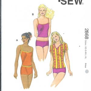 Peut inclure: Patron Kwik Sew 2868 pour tailles XS-S-M-L-XL. L'enveloppe présente des illustrations de trois tenues : un débardeur et un short orange, un débardeur et un short violet, et un haut à col en V jaune à motifs avec un short violet. Détails inclus.