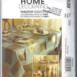 Op de afbeelding: Een naaipatroon voor tafelessentials, waaronder een tafelkleed, placemats en servetten. Het patroon bevat instructies voor het maken van een tafelkleed met een geruit patroon en een bloemenontwerp, evenals placemats en servetten met een bijpassend ontwerp. Het patroon is voor maat OSZ.