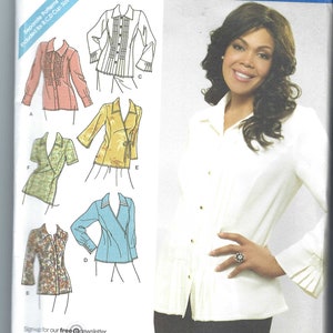 May include: Simplicity sewing pattern featuring the Khaliah Ali Collection. The pattern includes multiple blouse designs, with illustrations of each style. The image also shows a woman wearing a white blouse with pleats and gold buttons.
