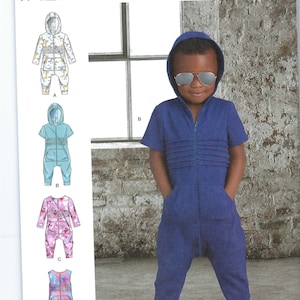 May include: Simplicity sewing pattern R11339 for children's jumpsuits. The pattern includes multiple jumpsuit designs with hoods, zippers, and pockets. The image shows a child wearing a blue jumpsuit with a hood and sunglasses.
