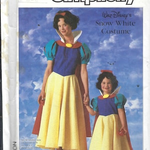 May include: Simplicity sewing pattern featuring a Snow White costume. The pattern shows a woman and child wearing the costume, which includes a blue bodice, yellow skirt, red cape, and white collar. The pattern is labeled with the number 7735.