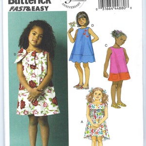 May include: A sewing pattern for a girl's dress. The pattern includes four different styles: a floral print dress with a bow, a blue dress with a scalloped hem, a pink dress with a red pocket, and a floral print dress with a ruffled neckline. The pattern is from Butterick and is labeled "Fast & Easy".