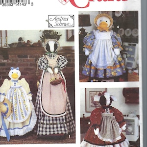 Peut inclure: Patron Simplicity Crafts présentant des modèles de poupées. L'image montre plusieurs poupées en tissu, dont un canard, un blaireau et une vache, chacune vêtue de vêtements détaillés de style vintage. Le patron est signé "Andrea Schewe".