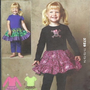 May include: Kwik Sew pattern 3729 for toddlers, featuring designs for a long-sleeve top with a graphic, a ruffled skirt, and leggings. The cover shows a black top with a skull and crossbones motif, a pink leopard print skirt, and black leggings.