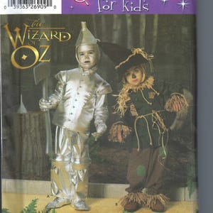 May include: A sewing pattern for children's costumes of the Tin Man and Scarecrow from the Wizard of Oz. The pattern is for sizes 3-8. The image shows a child dressed as the Tin Man and another child dressed as the Scarecrow.